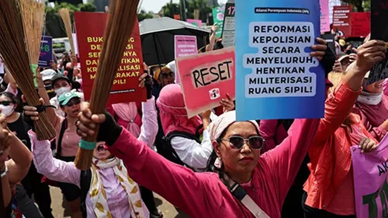 Indonesian women protest in pink with brooms 